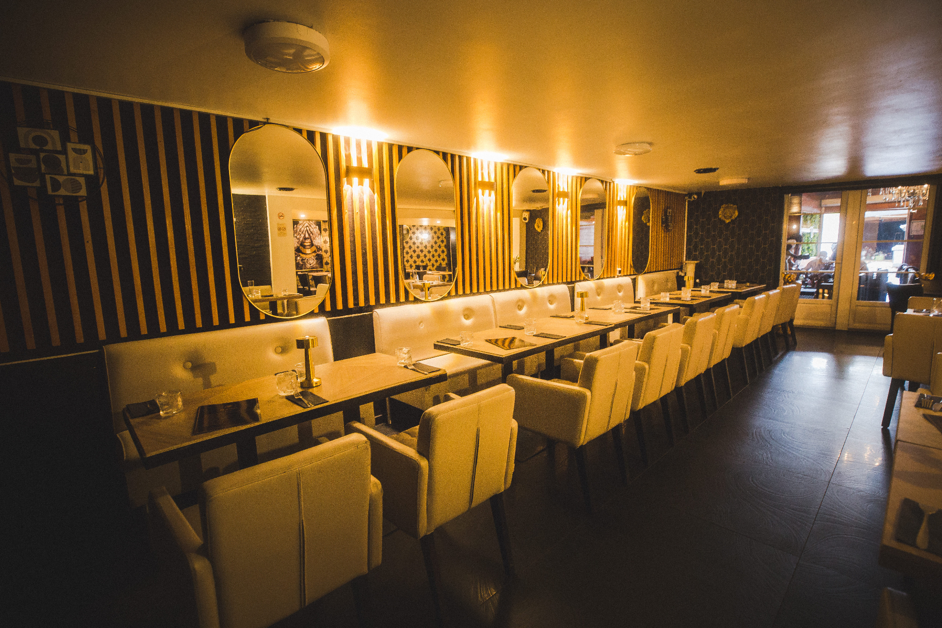 Salle à manger avec miroirs ovales et banquette